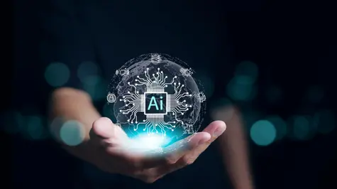 Obrazek przedstawia osobę trzymającą w dłoni futurystyczną kulę symbolizującą sztuczną inteligencję (AI).